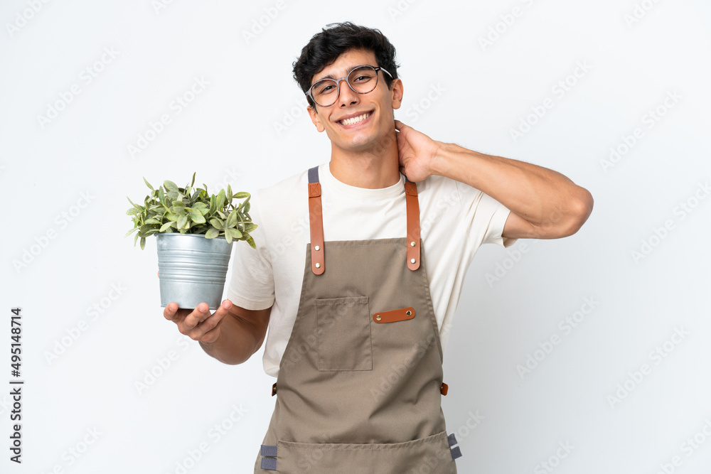 Gardener Argentinian man holding a plant isolated on white background laughing Gardener Argentinian man holding a plant isolated on white background laughing