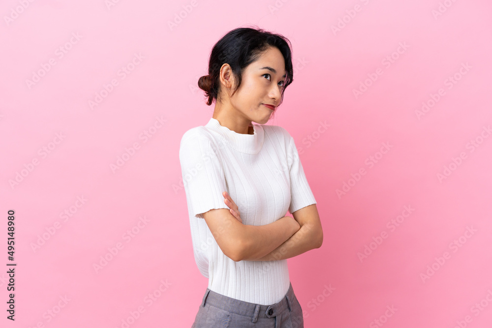 Young Vietnamese woman isolated on pink background making doubts gesture while lifting the shoulders Young Vietnamese woman isolated on pink background making doubts gesture while lifting the shoulders