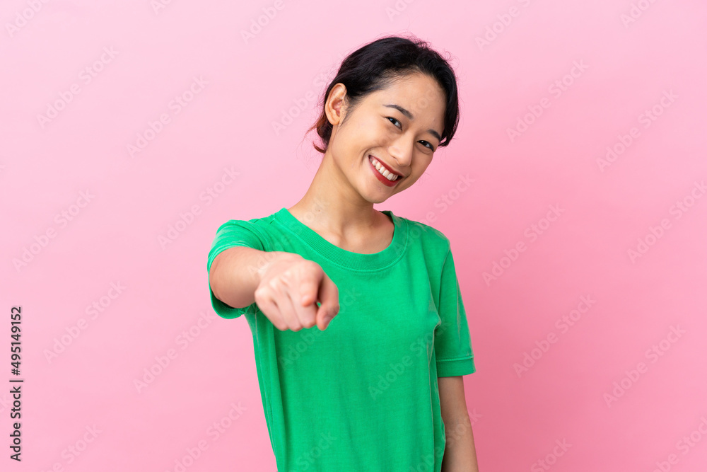 Young Vietnamese woman isolated on pink background pointing front with happy expression Young Vietnamese woman isolated on pink background pointing front with happy expression
