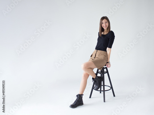 Beautiful elegant woman sitting on a chair of model appearance on a white background