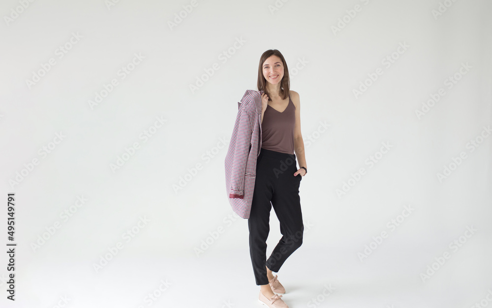 a beautiful woman with a jacket over her shoulder. Full-length portrait isolated on a white studio background. a beautiful woman with a jacket over her shoulder. Full-length portrait isolated on a white studio background.