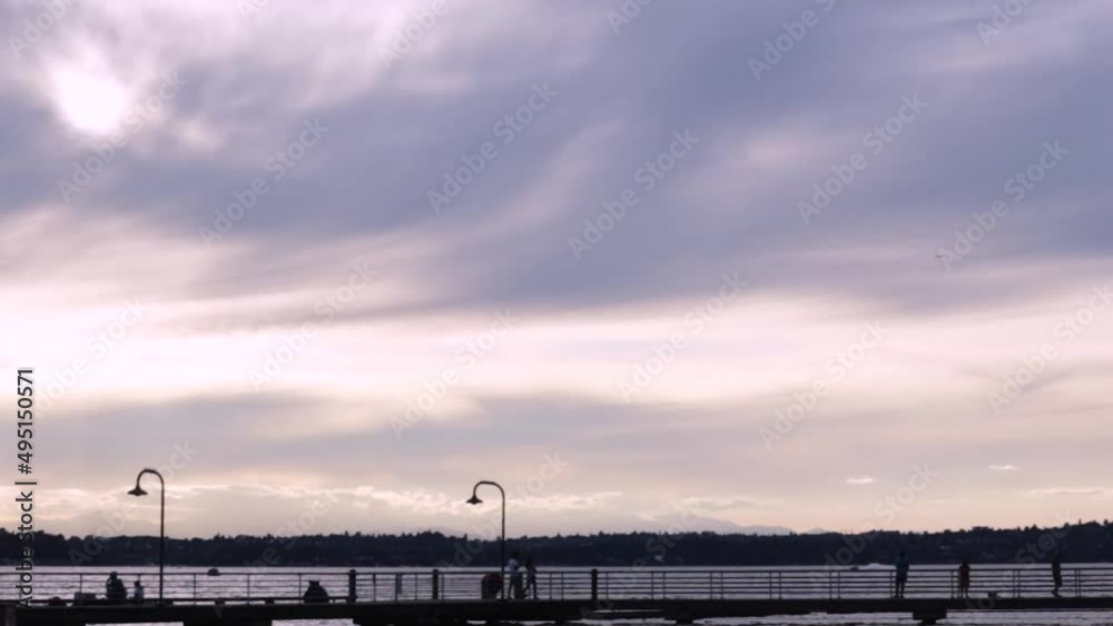 bright cloudy sky over a dark silhouetted boardwalk bright cloudy sky over a dark silhouetted boardwalk