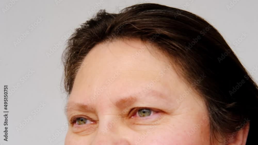 close-up of mature charismatic woman 50 years looks at the camera, eyes and forehead, small wrinkles on the face, overhang, the concept of cosmetic anti-aging procedures, facial massage close-up of mature charismatic woman 50 years looks at the camera, eyes and forehead, small wrinkles on the face, overhang, the concept of cosmetic anti-aging procedures, facial massage
