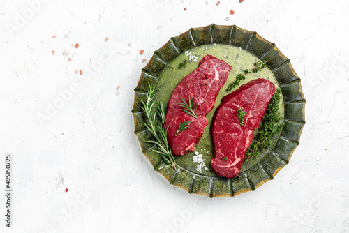 Pieces of cooked rump steak with spices served on old meat tray. Steak of marbled beef black Angus. Raw beef ramp steak, top view photo