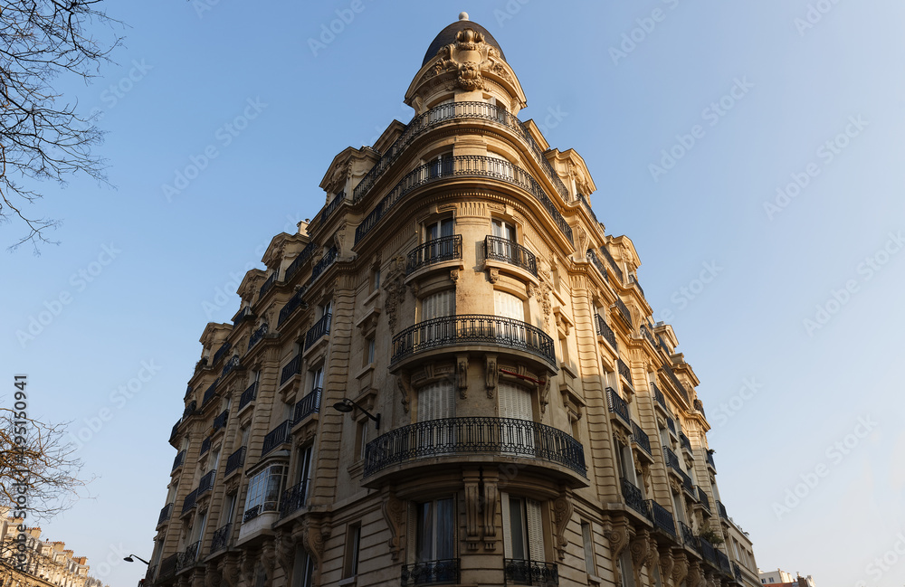 The facade of traditional French house with typical balconies and windows. Paris.