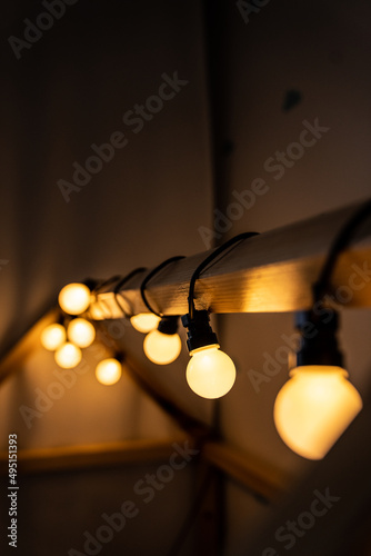 Obraz na płótnie lights - garland - children's room - warm light on a wooden house w salonie
