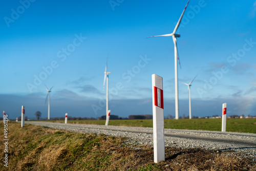 Obraz na płótnie Fahrbahnmarkierungen - Feldweg im Hintergrund Windpark - Dorf w salonie
