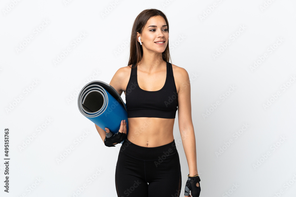 Young sport woman isolated on white background with a mat and smiling Young sport woman isolated on white background with a mat and smiling
