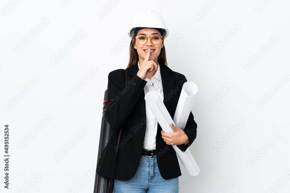Young architect caucasian woman with helmet and holding blueprints over isolated background doing silence gesture Young architect caucasian woman with helmet and holding blueprints over isolated background doing silence gesture