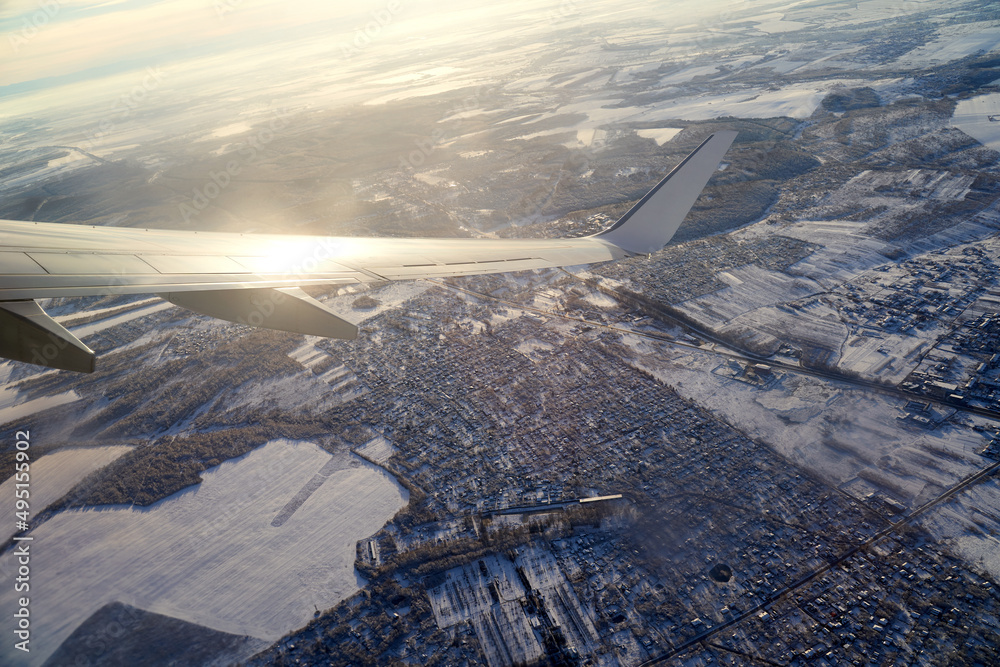 Takeoff of the plane. Flying and traveling. View from airplane window on the wing during sunset in winter.