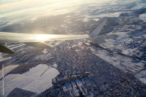 Obraz na płótnie Takeoff of the plane. Flying and traveling. View from airplane window on the wing during sunset in winter. w salonie
