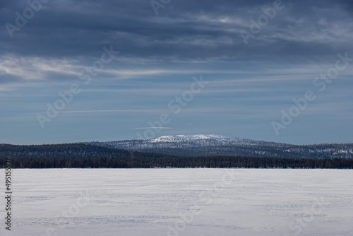 snow frozen lake and mountain in the distance in beautiful north finish lapland