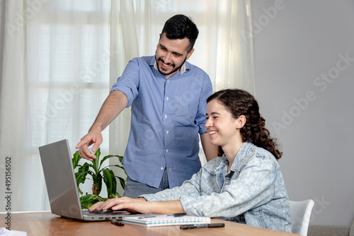 Trabajadores de oficina exitosos ríen mientras miran el ordenador. Trabajo de oficina.