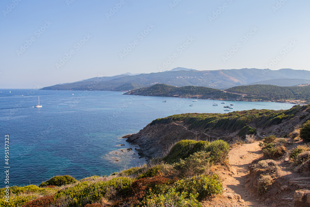 Sailing boats having dropped anchor near the coast of Corsica in a translucent, clear and calm Mediterranean sea