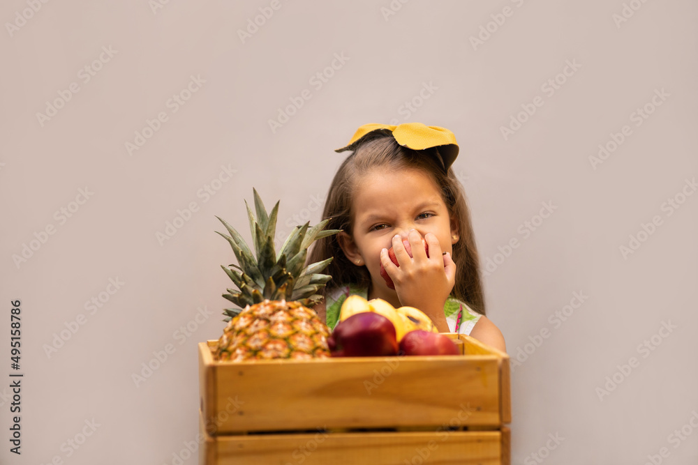 niña feliz disfrutando comiendo a mordidas una rica y jugosa manzana alimento comida rojo mordiendo fruta tropical - obrazy, fototapety, plakaty 
