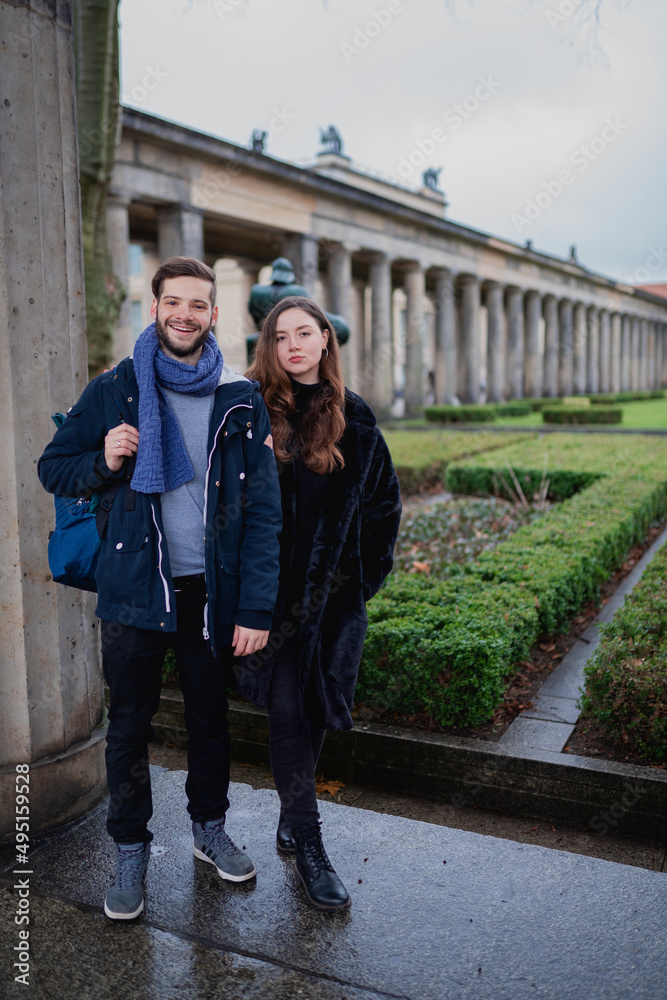 Young caucasian brunette couple in the colonnade walking in the city of Berlin. German adult couple