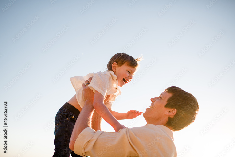Father Lifting Up Son at Sunset on Beach in San Diego Father Lifting Up Son at Sunset on Beach in San Diego