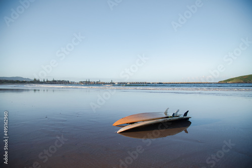Two surfboards on the beach at sunset with jetty in the distance. Coffs Harbour, Australia © Caseyjadew