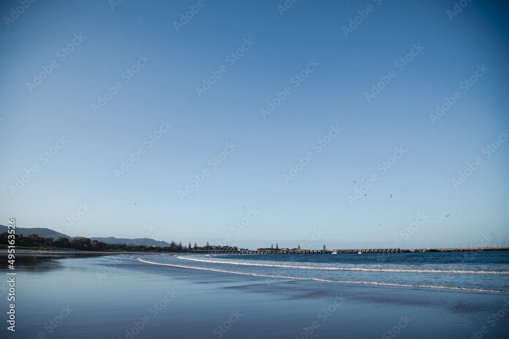 Waves rolling in on Coffs Harbour Beach with jetty in the distance, Australia Waves rolling in on Coffs Harbour Beach with jetty in the distance, Australia