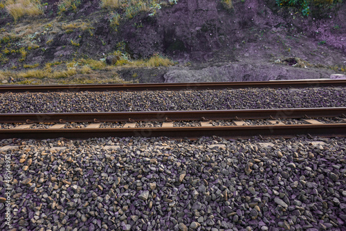 The railroad tracks pass through the grooved bearings buried under the shards of cobblestone