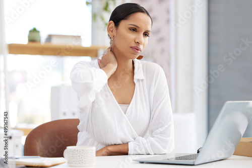 Need a break. Shot of a young businesswoman sitting at a desk looking tired in a modern office.