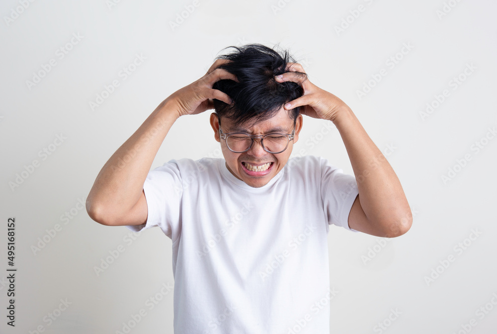A young Asian man is stressed and anxious and has a white background. A young Asian man is stressed and anxious and has a white background.
