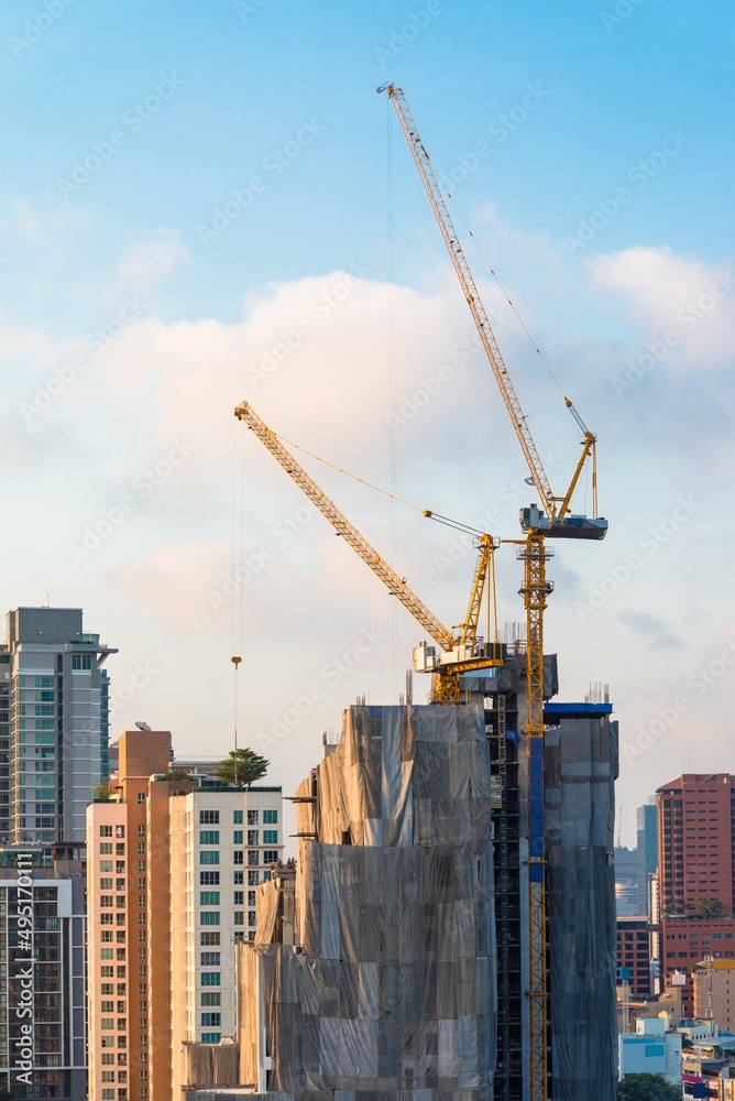 Modern building and tower crane in construction site. Construction industry concept.