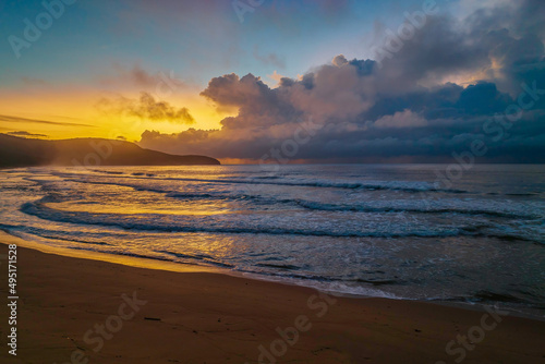 Sunrise seascape with rain clouds on the horizon