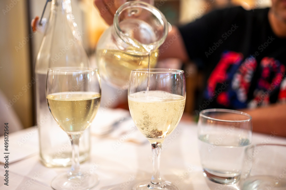 Italian white house wine served in pitcher with two glasses for dinner