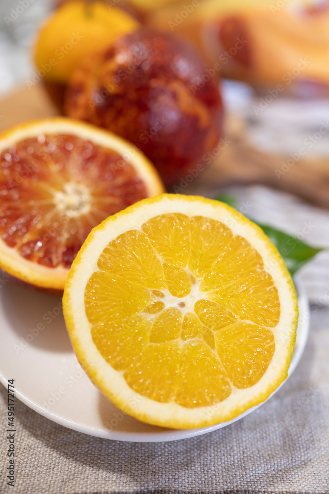 Sicilian sweet juicy yellow and red blood oranges with green leaves close up Sicilian sweet juicy yellow and red blood oranges with green leaves close up