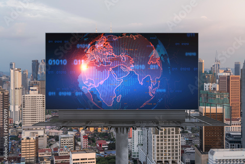 Glowing hologram of Earth planet map on billboard over aerial panoramic cityscape of Kuala Lumpur at sunset, Malaysia, Asia. The concept of international business in KL.
