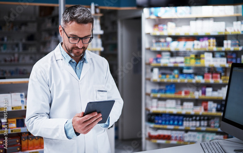 Always informed, just what you want from your pharmacist. Shot of a handsome mature pharmacist using a digital tablet in a pharmacy. © T Hinrichsen/peopleimages.com