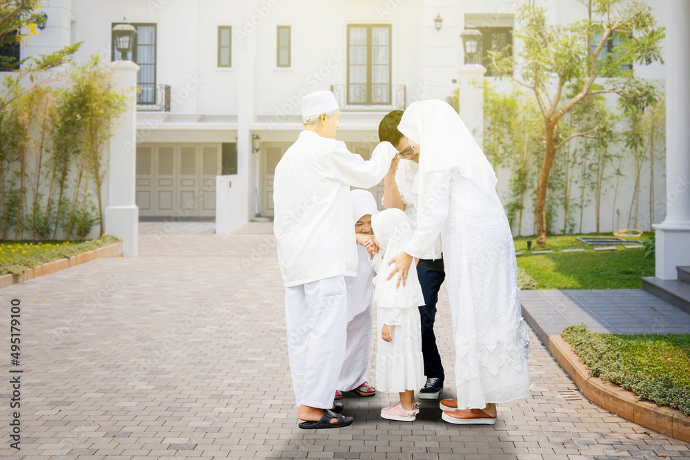 Three generation family handshaking during Eid