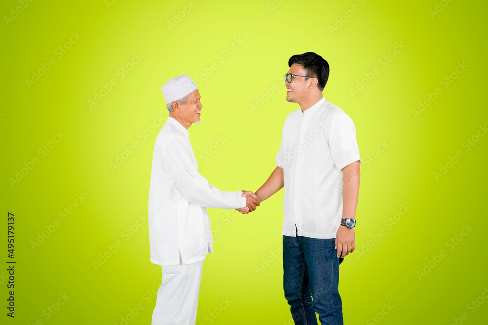 Young man handshake with his father on studio Young man handshake with his father on studio