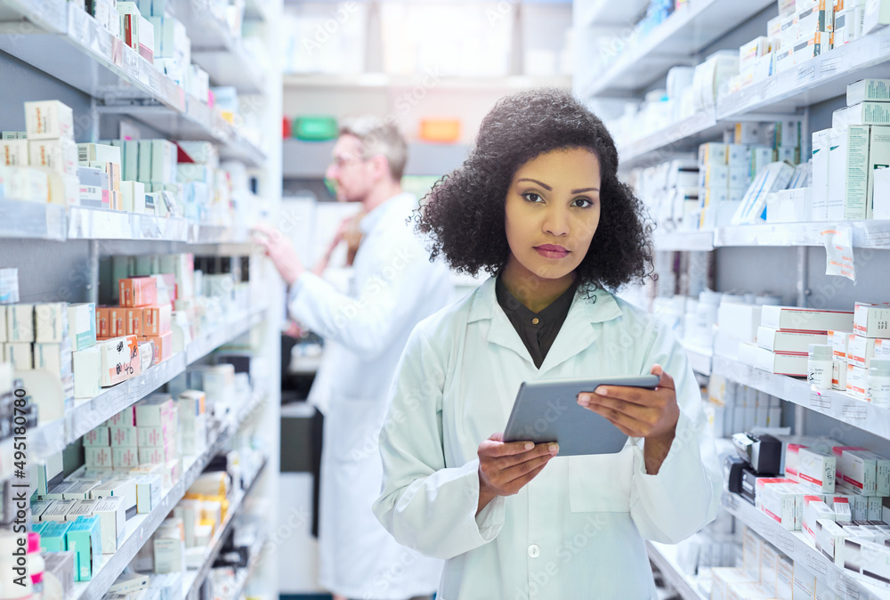 Its the smartest way to manage a modern pharmacy. Shot of a young woman using a digital tablet to do inventory in a pharmacy.