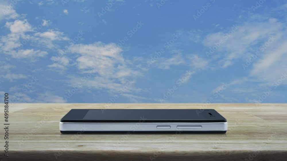 Power button flat icon on modern smart mobile phone screen on wooden table over blue sky with white clouds, Business start up online concept Power button flat icon on modern smart mobile phone screen on wooden table over blue sky with white clouds, Business start up online concept