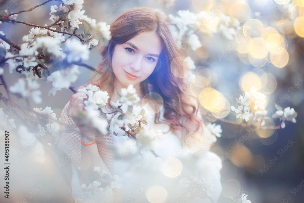 spring portrait of an adult happy woman in a blooming garden, sun rays and glare, april flowers girl spring portrait of an adult happy woman in a blooming garden, sun rays and glare, april flowers girl