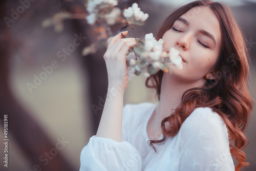 happy girl dreaming in a blooming garden, fresh tenderness spring woman in flowers