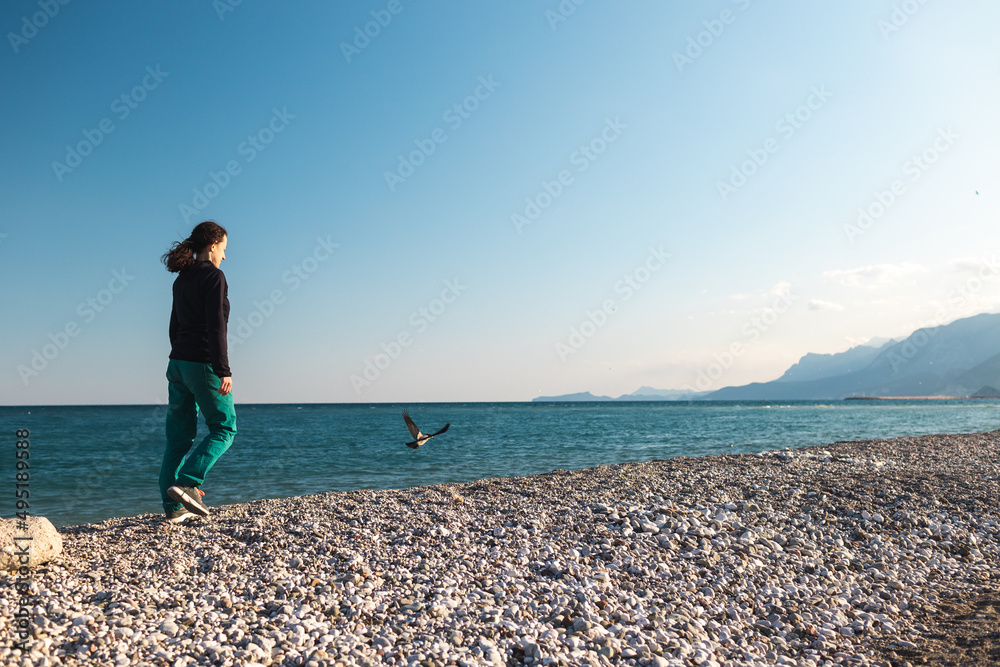 A girl walks along the beach alone