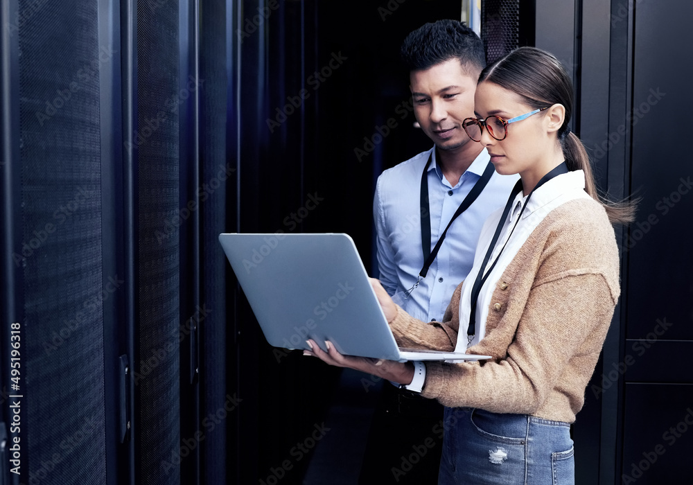 No one knows networking like they do. Shot of two technicians working together in a server room. - obrazy, fototapety, plakaty 
