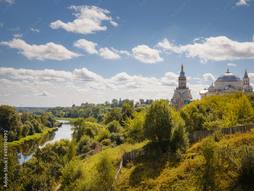 summer travel to Russia, Torzhok city, Tver region. View on old buildings at the embankment from the bridge across the Tvertsa river. Rural landscape
