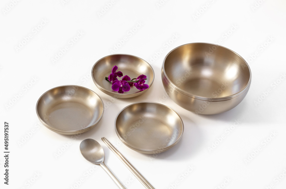 Korean high quality brass tableware with chopsticks isolated on white background.
