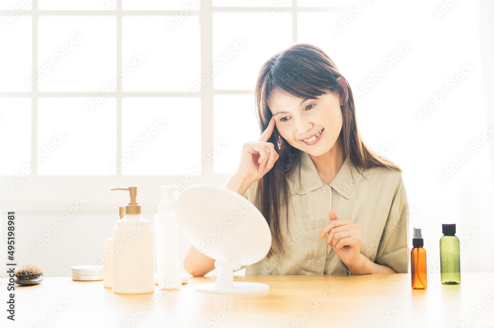 鏡を見るミドル世代の女性（目元）
