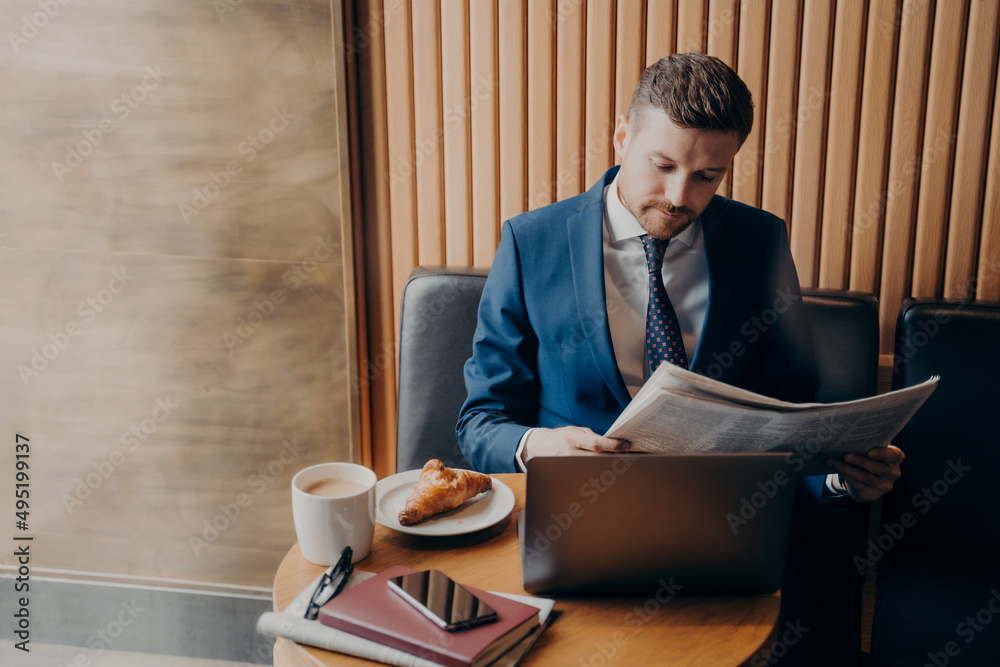 Young man entrepreneur in formal tuxedo reading newspaper in cafe Young man entrepreneur in formal tuxedo reading newspaper in cafe