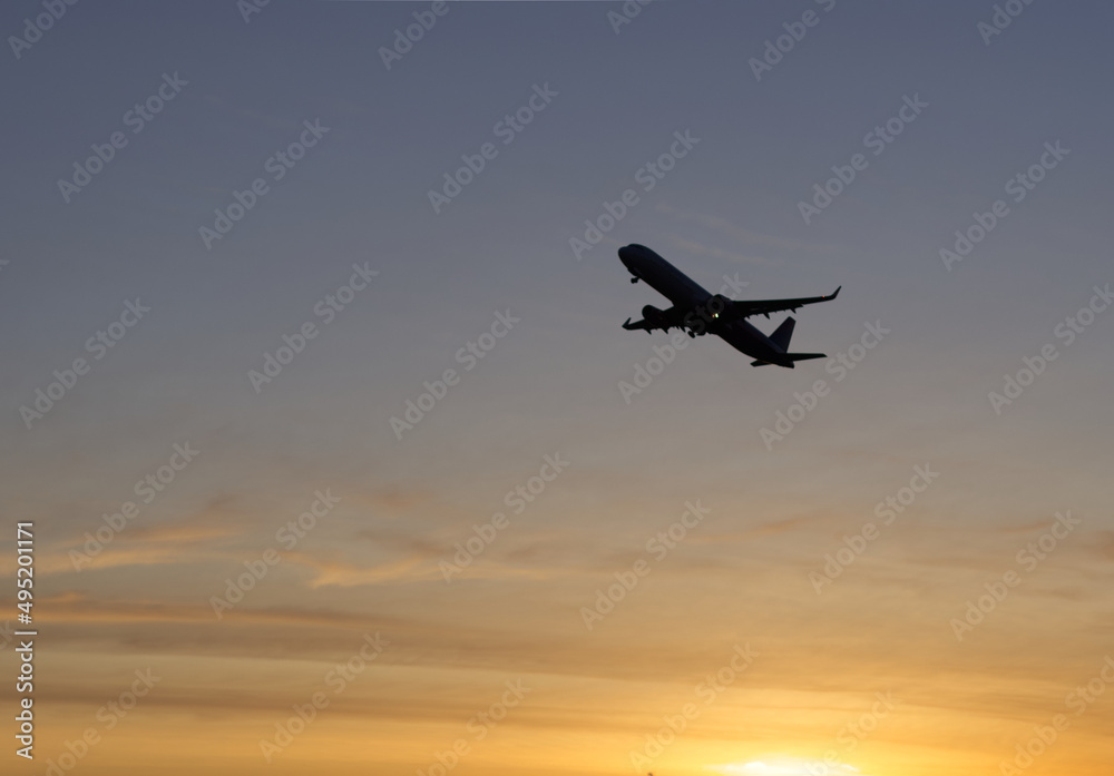 Naklejka premium Airplane in the sky at sunrise
