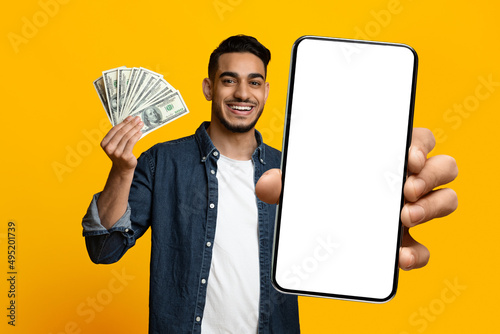 Positive handsome middle eastern guy showing cell phone and cash