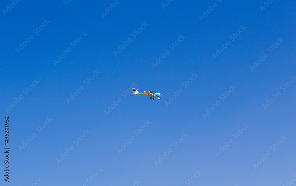 Ultra light, cessna plane from side with prolonge rope on blue sky. Sport, transportation background Ultra light, cessna plane from side with prolonge rope on blue sky. Sport, transportation background
