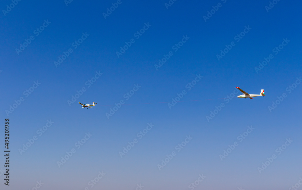 Ultra light, cessna plane drag on glider with prolonge rope on blue sky. Sport, aviation background Ultra light, cessna plane drag on glider with prolonge rope on blue sky. Sport, aviation background