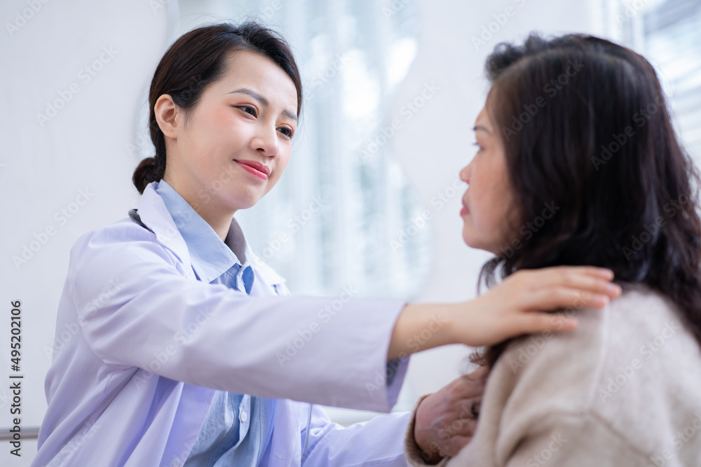 Asian female doctor examining an elderly woman at home Asian female doctor examining an elderly woman at home