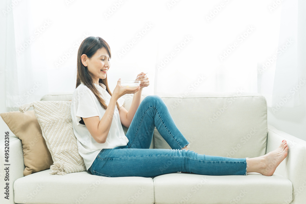 ソファでヨーグルトを食べる女性(笑顔)
ソファでヨーグルトを食べる女性(笑顔)